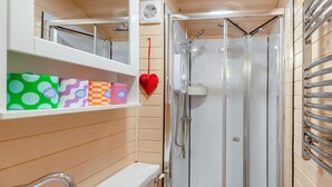 A bathroom with a shower, a sink, and a shelf with colorful boxes. - 1 Bed in Shipley (oc-s34110) (Shipley)