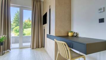 A modern room with a desk, chair, and a television.