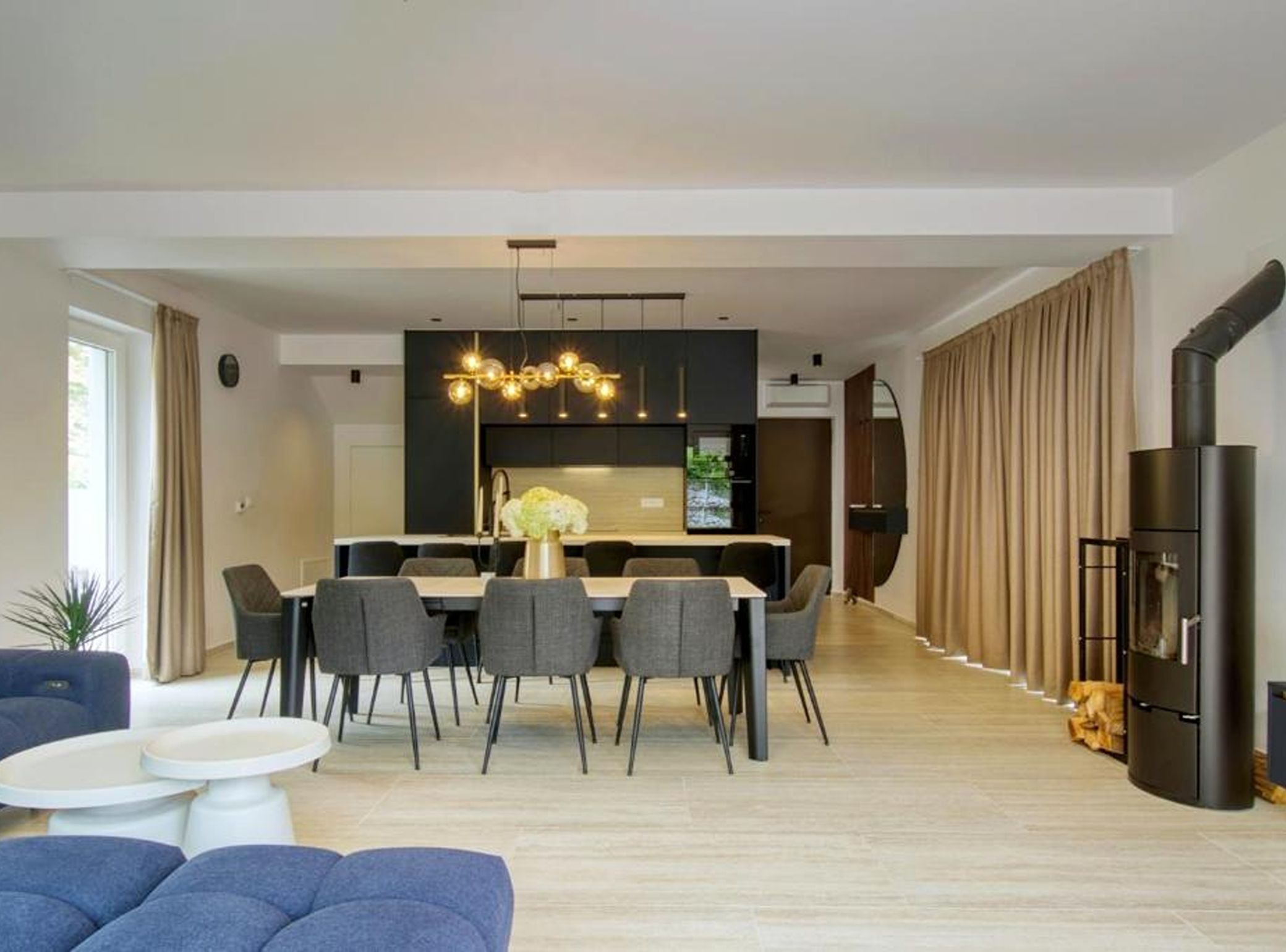 A modern living room with a dining area, a sofa, and a TV.