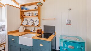 A compact kitchenette with a sink, stove, and storage cabinets. - 1 Bed in West Yelland (oc-o45728) (Braunton)