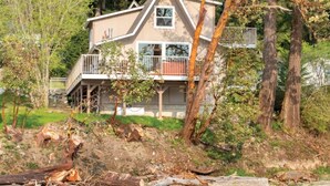 A two-story house with a balcony, surrounded by trees and a natural landscape. - WM BLOCK Deer Harbor 1br (Deer Harbor)
