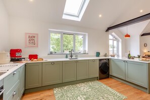 A kitchen with a skylight, a coffee machine, a washing machine, and a window with a view of greenery. - 1 Bed in Eggesford (oc-l45452) (Wembworthy)