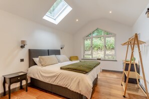 A bedroom with a bed, a bedside table, a window, and a skylight. - 1 Bed in Eggesford (oc-l45452) (Wembworthy)