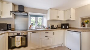 A modern kitchen with white cabinetry, a built-in oven, a microwave, and a dishwasher. - 2 Bed in Appersett (oc-d45772) (Appersett)