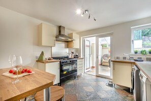A modern kitchen with a central island, a stove, oven, and a dishwasher. - 2 Bed in Cockermouth (oc-b44967) (Cockermouth)