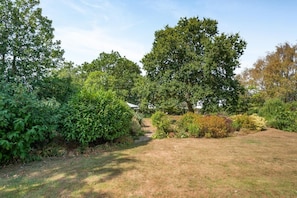 A landscaped garden with a variety of trees and shrubs, a clear sky, and a well-maintained lawn. - 1 Bed in Sibsey (oc-s45757) (Sibsey)