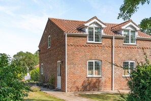 A two-story brick building with a pitched roof, multiple windows, and a small porch area. - 1 Bed in Sibsey (oc-s45757) (Sibsey)