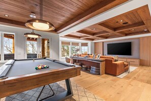 A modern living room with a pool table, a sofa, a television, and a wooden ceiling. - Abode at Sun Ridge, private hot tub, stunning interior, Deer Valley (Park City)