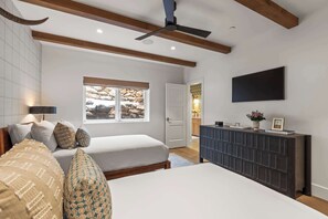 A bedroom with a bed, a dresser, a window with a view of rocks, and a ceiling fan. - Abode at Sun Ridge, private hot tub, stunning interior, Deer Valley (Park City)