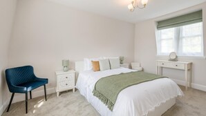 A bedroom with a bed, a chair, a nightstand, a dresser, and a window with curtains. - 2 Bed in Overstrand (oc-s45741) (Overstrand)