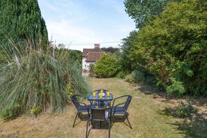 A patio with a table and chairs, surrounded by grass and various plants. - 2 Bed in Overstrand (oc-s45741) (Overstrand)