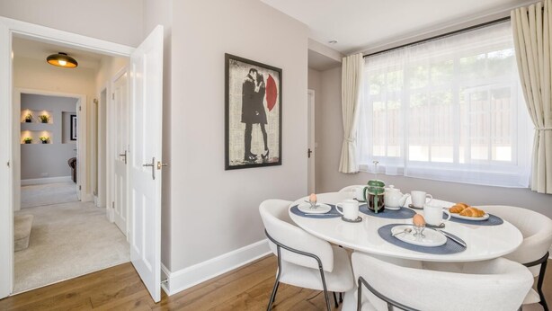 A dining area with a round table, chairs, a painting, and a window with curtains. - 2 Bed in Overstrand (oc-s45741) (Overstrand)
