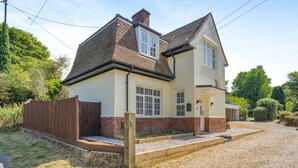 A two-story house with a brick facade, a gravel driveway, and a wooden fence. - 2 Bed in Overstrand (oc-s45741) (Overstrand)