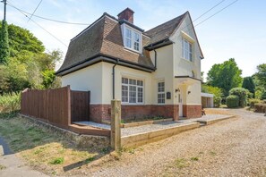 A two-story house with a brick facade, a gravel driveway, and a wooden fence. - 2 Bed in Overstrand (oc-s45741) (Overstrand)
