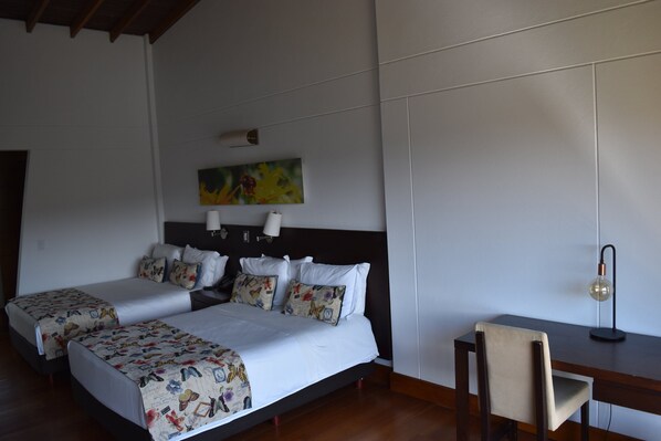 A hotel room with a double bed, two bedside tables, a desk, and a chair. - Hotel Piedras Blancas (Guarne)