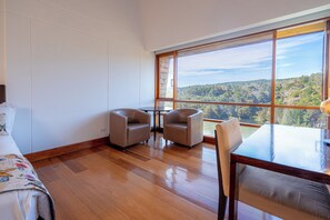 A room with a large window, two chairs, a small table, and a bed. - Hotel Piedras Blancas (Guarne)
