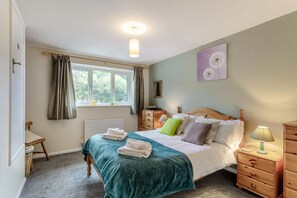 A bedroom with a bed, bedside tables, a dresser, a window with curtains, a radiator, and a wall-mounted lamp. - 2 Bed in Beer (oc-h45729) (Beer)