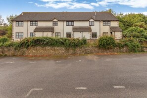 A two-story building with a stone wall and a paved driveway. - 2 Bed in Beer (oc-h45729) (Beer)