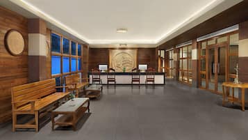A reception area with wooden benches, a reception desk, and a large wall-mounted emblem.