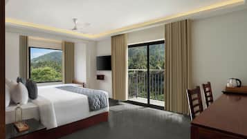 A hotel room with a bed, a TV, a balcony, and a dining area.