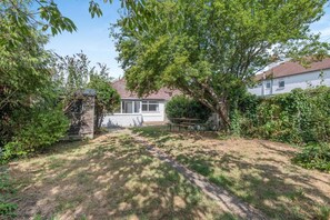 A residential property with a paved driveway, a covered patio, and a well-maintained lawn. - 2 Bed in Whitstable (oc-o45433) (Whitstable)