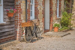 A bicycle with a basket parked against a brick wall with a window. - 3 Bed in Marnhull (oc-o45408) (Marnhull)