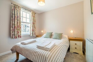 A bedroom with a bed, two bedside tables, a window with curtains, and a radiator. - 3 Bed in Marnhull (oc-o45408) (Marnhull)
