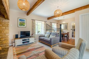 A cozy living room with a sofa, a television, and a patterned rug. - 3 Bed in Marnhull (oc-o45408) (Marnhull)