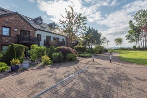 A residential area with a paved driveway, a brick house, and well-maintained landscaping. - 1 Bed in Berrier (oc-g45742) (Hutton)