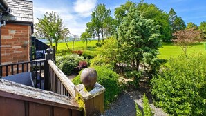 A residential property with a brick building, a wooden staircase, and a view of a green landscape with trees and a golf course. - 1 Bed in Berrier (oc-m45743) (Hutton)
