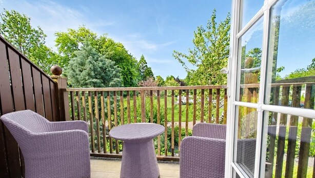 A covered outdoor area with wicker furniture, including chairs and a small round table. - 1 Bed in Berrier (oc-m45743) (Hutton)