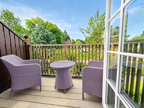 A covered outdoor area with wicker furniture, including chairs and a small round table. - 1 Bed in Berrier (oc-m45743) (Hutton)
