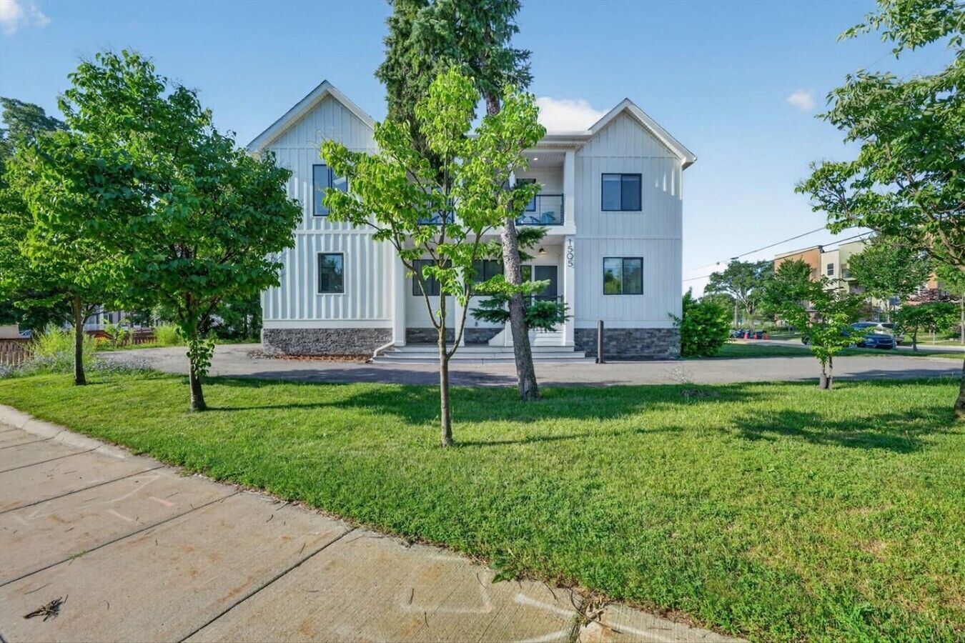 A two-story residential building with a symmetrical facade, a central entrance, and a small porch area.