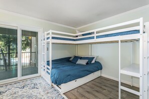 Ein Schlafraum mit Etagenbetten und einer Glastür zum Balkon.