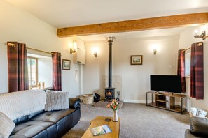 A living room with a sofa, a coffee table, a fireplace, and a television. - 2 Bed in Gilsland (oc-o45731) (Waterhead)