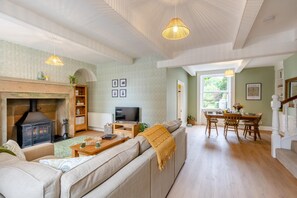 A cozy living room with a fireplace, sofa, and television. There is a dining area with a table and chairs. - 2 Bed in Gargrave (oc-k45568) (Gargrave)