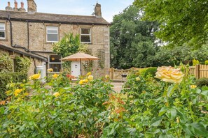 A stone house with a garden, a wooden fence, and a door with a keyhole. - 2 Bed in Gargrave (oc-k45568) (Gargrave)