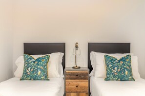 A double bed with white linens and two matching pillows with a bird and floral pattern. - 3 Bed in Challacombe (oc-s45342) (Challacombe)