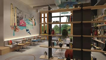 Una biblioteca moderna con estanterías, zonas de estar y un mural en la pared.