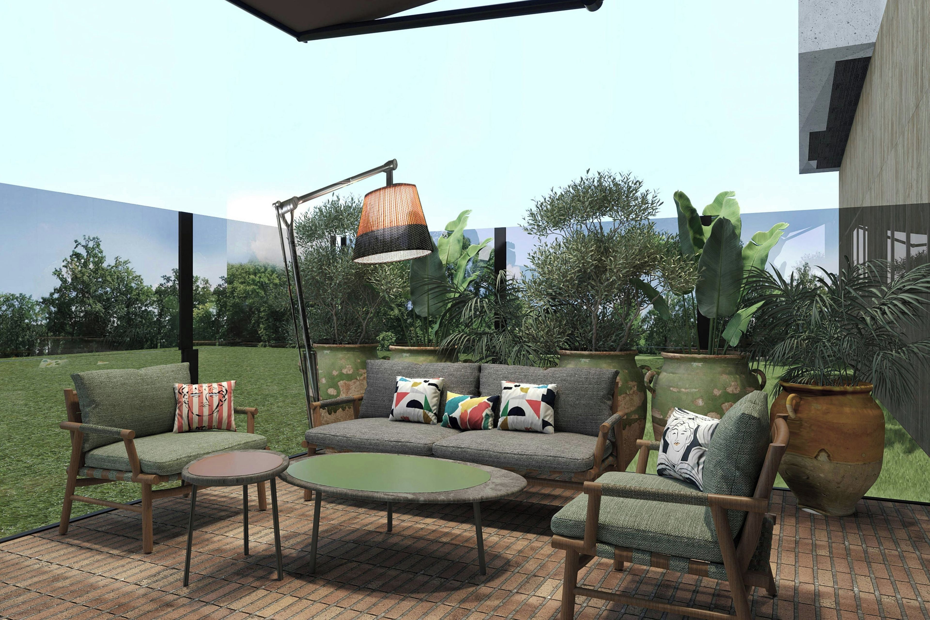 An outdoor patio area with a sofa set, a round table, and a floor lamp.
