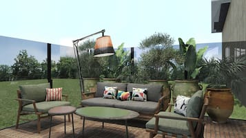 An outdoor patio area with a sofa set, a round table, and a floor lamp.