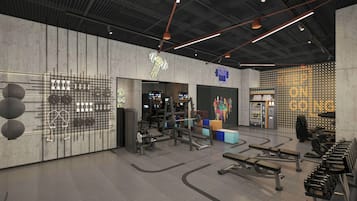 Un gimnasio moderno con diversos equipos de ejercicio, una zona de bar y una máquina expendedora.