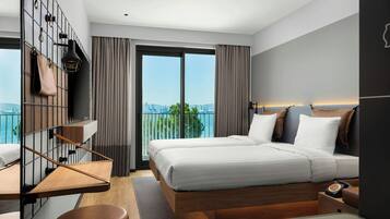 A modern hotel room with a large bed, a desk, and a view of the city.
