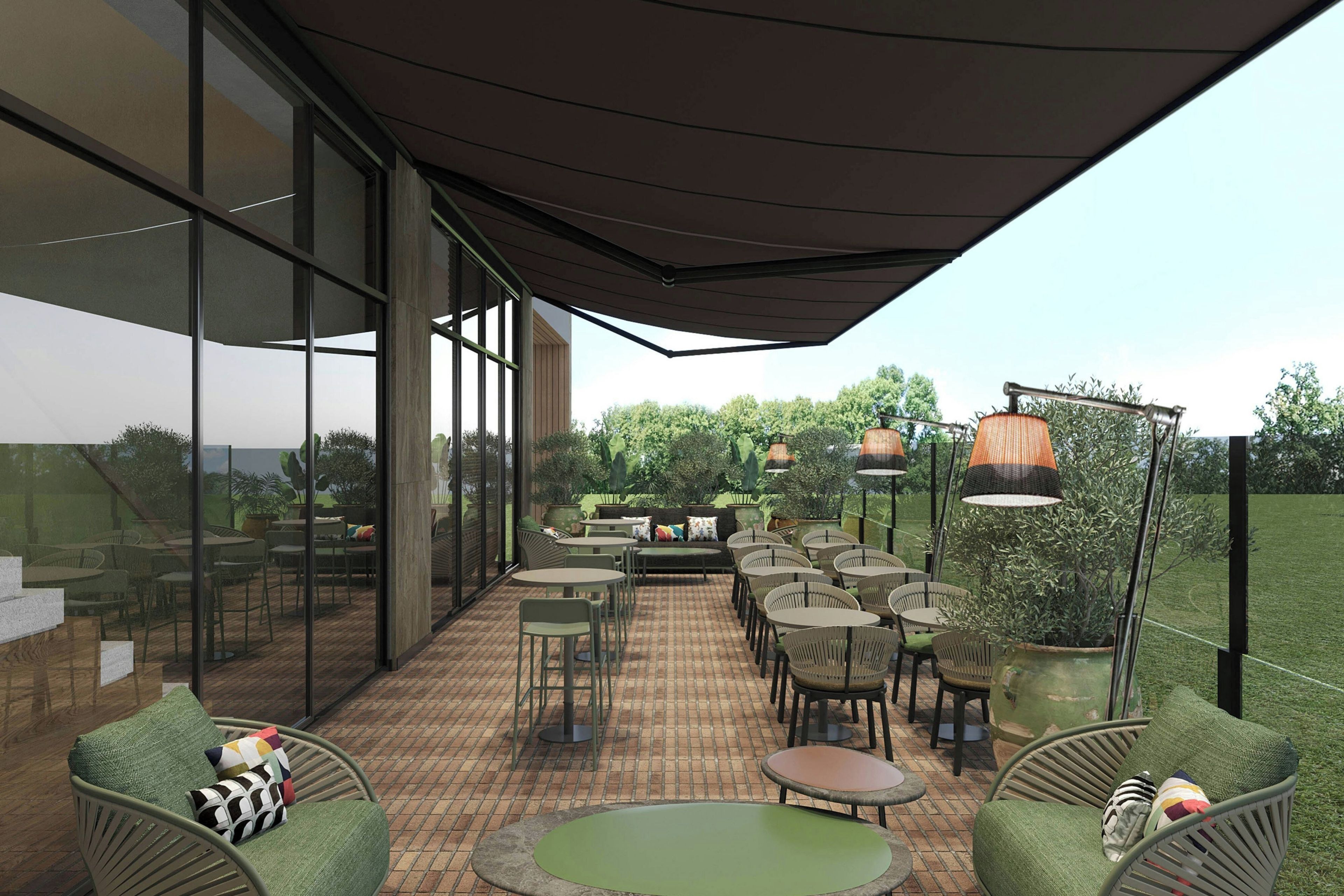 An outdoor patio area with round tables and chairs, a large umbrella, and potted plants.