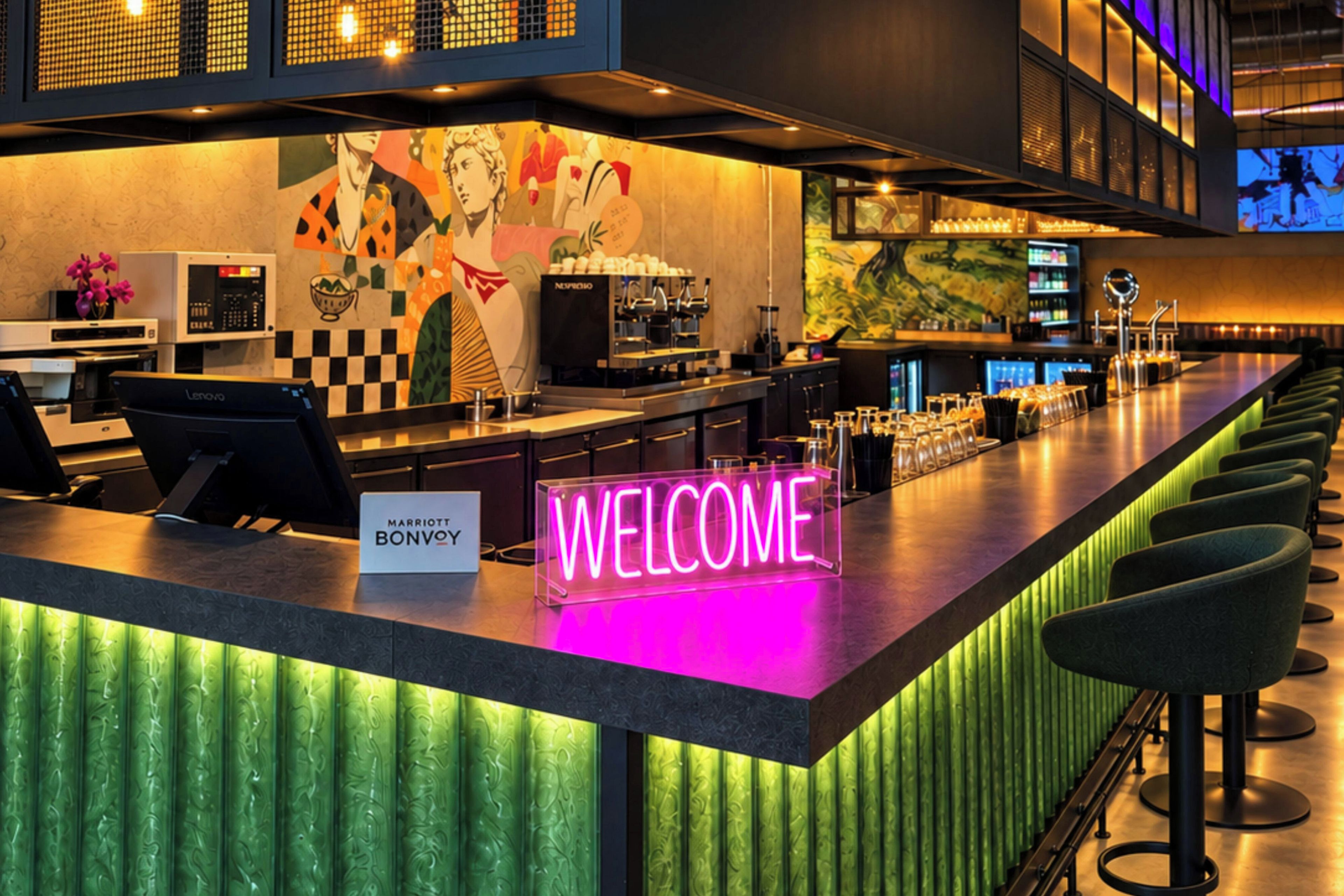 A bar area with a neon welcome sign, a coffee machine, and a seating area with bar stools.