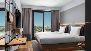 Une chambre d’hôtel moderne dotée d’un grand lit, d’un bureau, d’une chaise, d’une télévision et d’un balcon offrant une vue sur la ville.
