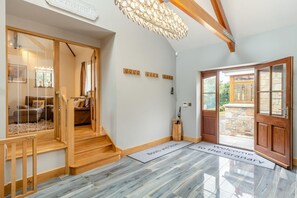 A hotel entrance with a wooden staircase, a reception desk, and a sign welcoming guests. - 3 Bed in Tremar Coombe (oc-g45783) (Tremar)
