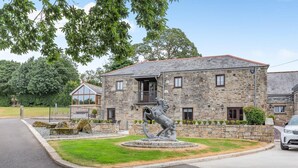 A stone building with a balcony, a horse statue, and a car parked in front. - 3 Bed in Tremar Coombe (oc-g45783) (Tremar)