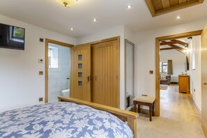 Ein Schlafzimmer mit einem Bett, einem Holzschrank und einer kleinen Bank.
