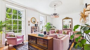 A room with a large window, a wooden cabinet, a sofa, and a mirror. - 4 Bed in Marple (oc-45774) (Marple)